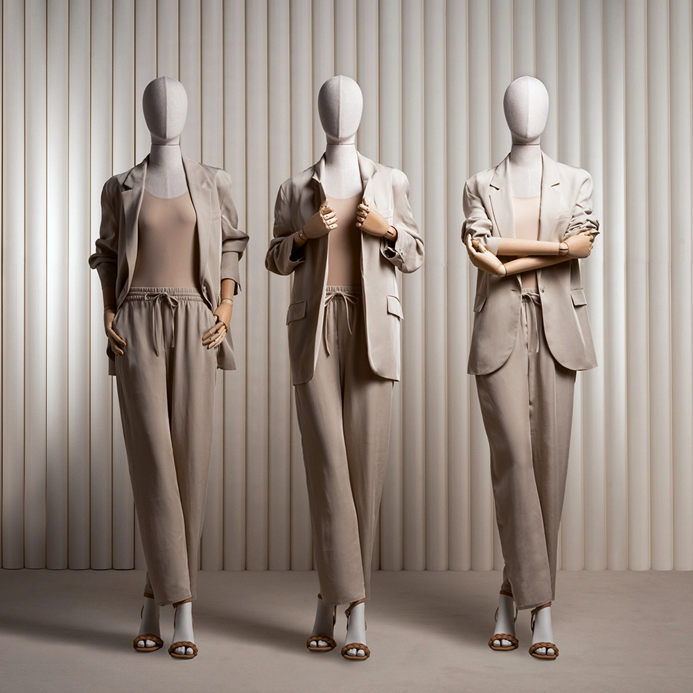 a group of three female mannequins from the essential collection wearing taupe suits