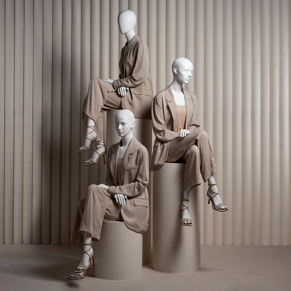 a group of three female mannequins from the essential collection wearing taupe suits