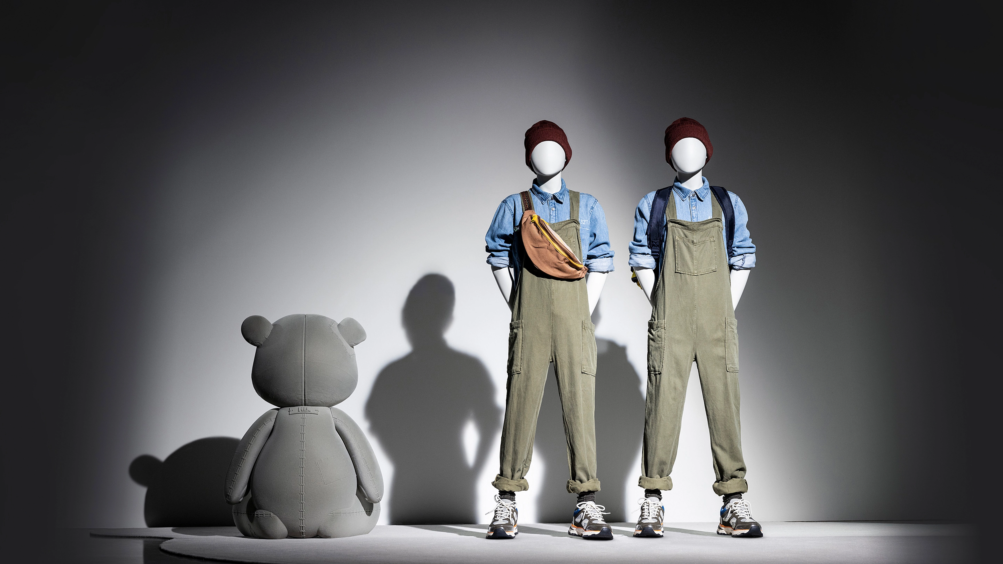 a pair of boy kids mannequins from the kids collection with a fuzzy bear next to them