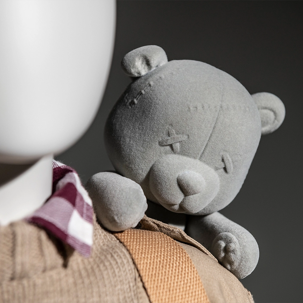 a closeup of a toy bear on a kids mannequin shoulder from the kids collection