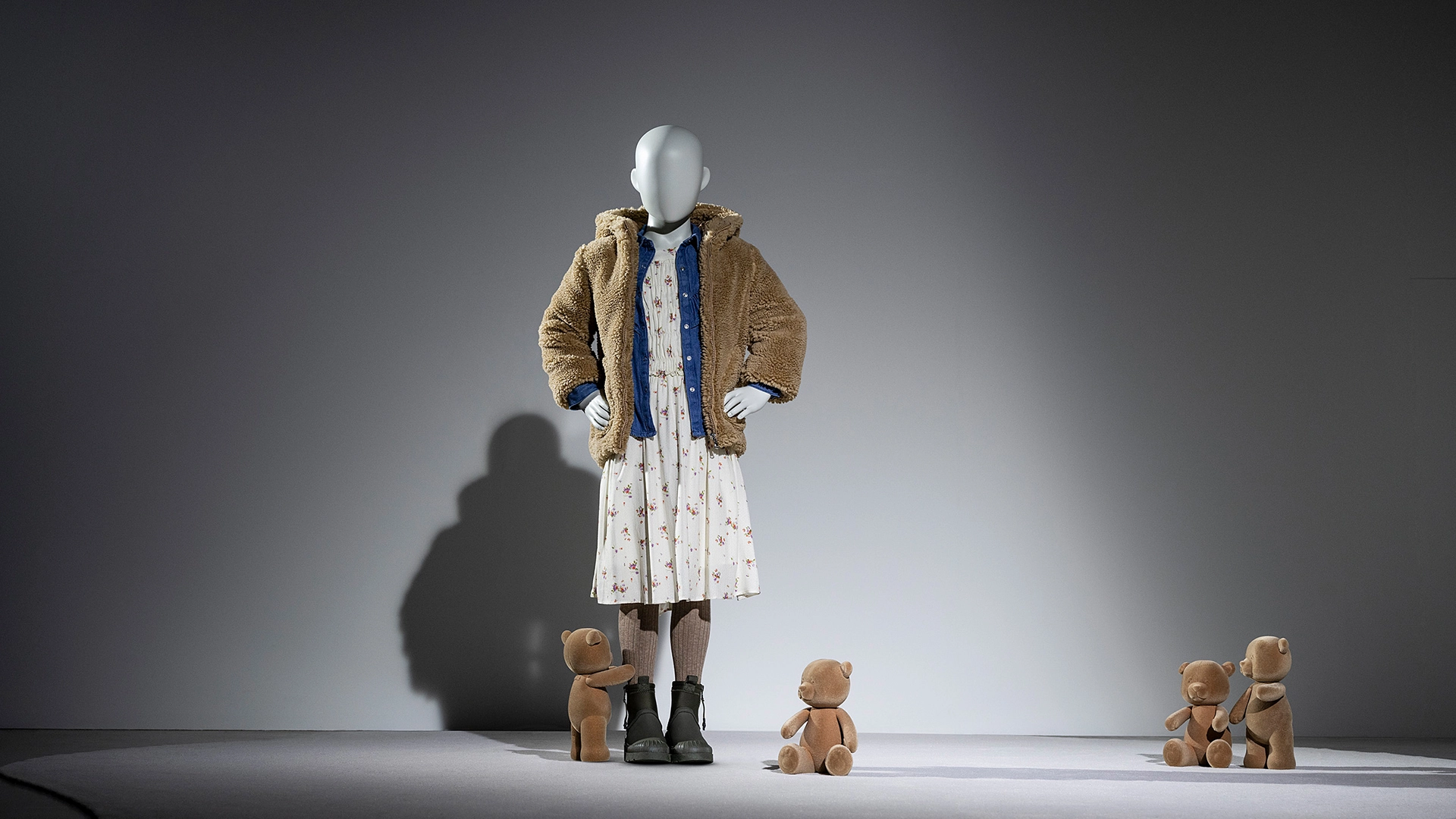 a girl kids mannequin from the kids collection surrounding by toy bears