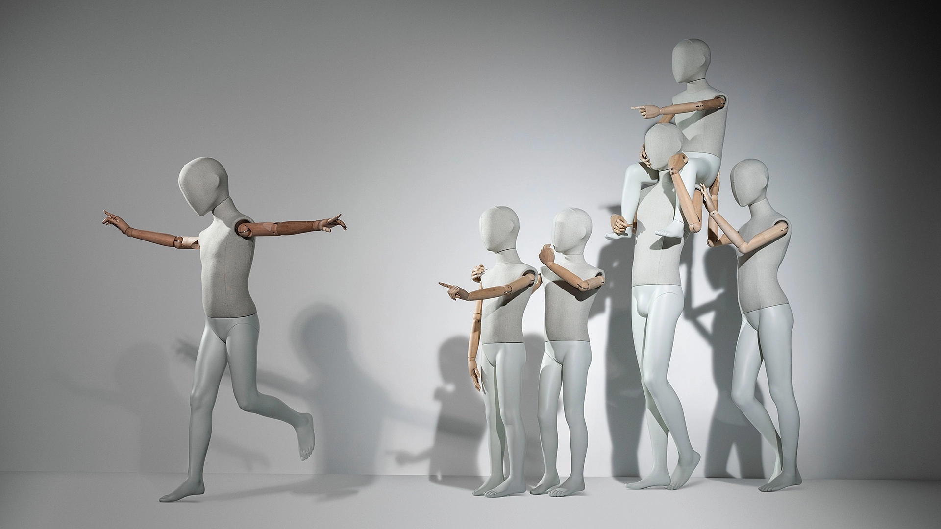 a group of articulated kids mannequins from the articulated kid collection, one is running away and the rest are pointing to him